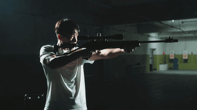Man aiming rifle at training range
