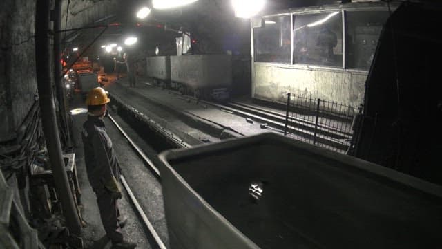 Miners working underground moving mining carts