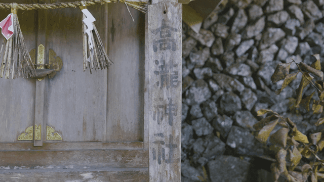 Traditional Japanese shrine with ropes inscribed with sacred Chinese characters