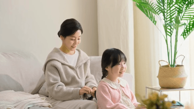Mother braiding her daughter's hair