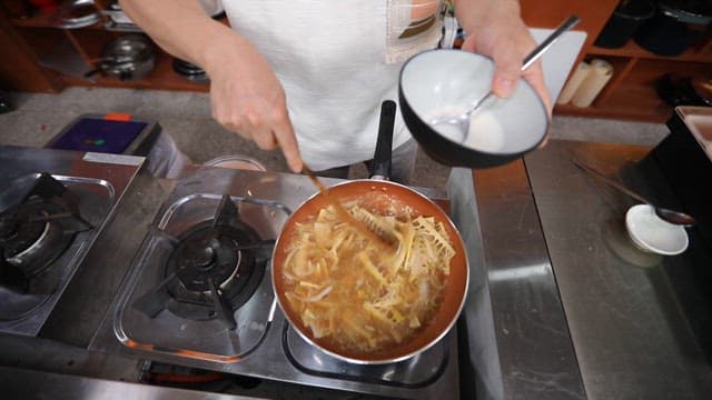 뜨거운 프라이팬에서 주걱으로 죽순 요리하기