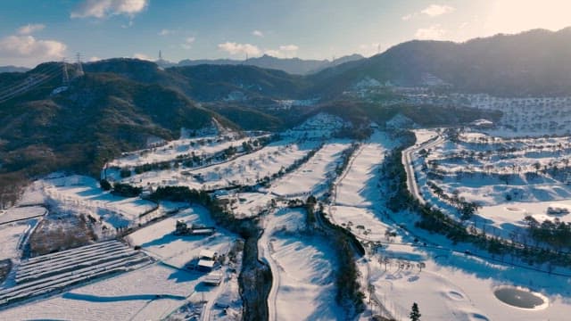 Snow-covered valley with winding roads at sunrise