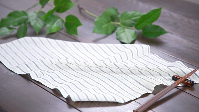 Plate of neatly plated half-dried saury on a wooden table