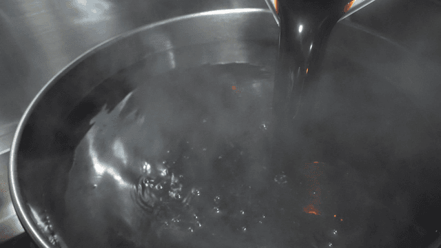 Soy sauce poured into boiling pot