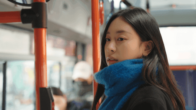Woman standing inside a moving bus