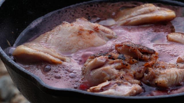 토마토 소스와 향신료가 추가되는 프라이팬의 닭고기 요리