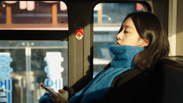 버스에서 휴대폰을 들고 있는 여성의 옆모습
