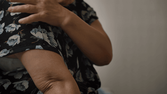 팔을 마사지하는 노인 여성