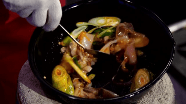 Stir-frying squid, green onions, and chili peppers in a pot