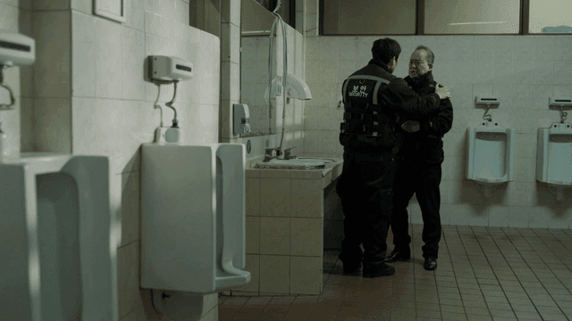 Two security guards talking in a restroom