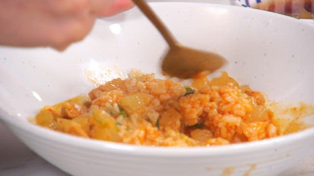 숟가락으로 비벼지는 돼지고기와 무볶음이 들어간 덮밥