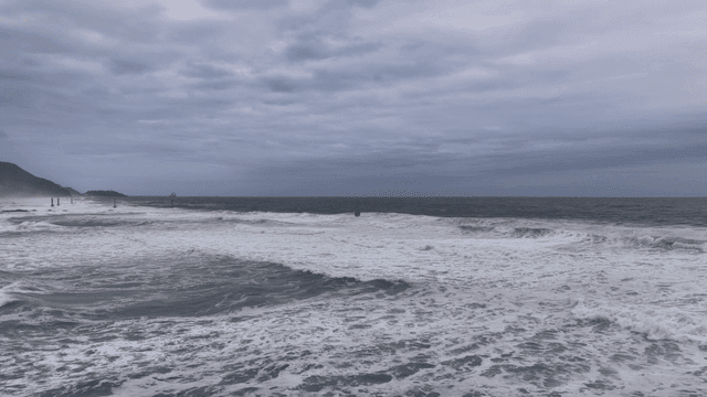 Vast sea with crashing waves beneath cloudy sky