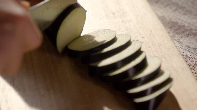 Slicing eggplant on a wooden board