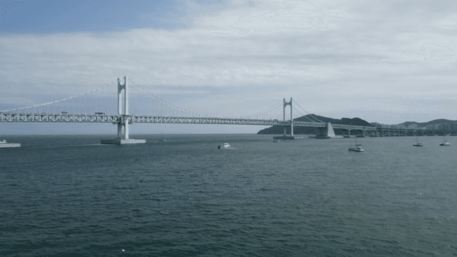 고요한 바다 위의 큰 다리와 보트