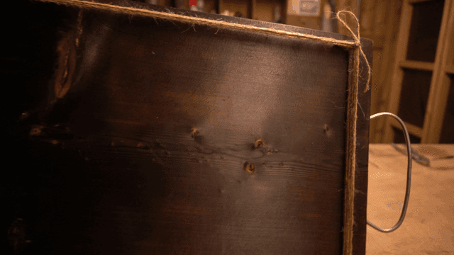 줄들이 묶인 못이 박힌 검은 나무 판자