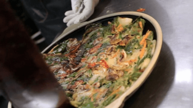 팬에서 요리한 해물 파전 그릇에 담기