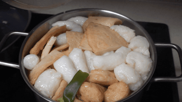 Pot full of boiling fish cake soup