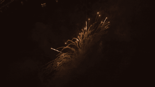 Fireworks display over river at night