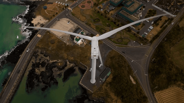 해안 도로 근처에서 회전하는 풍력 터빈