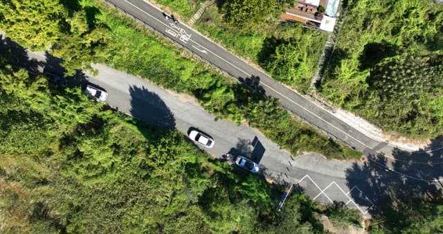 Cars on a winding road surrounded by greenery