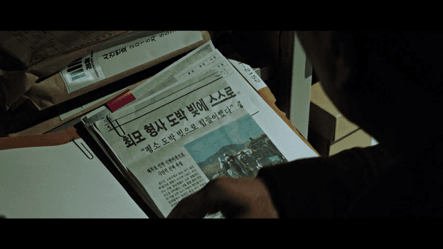 Back view of person reading case file in dark room