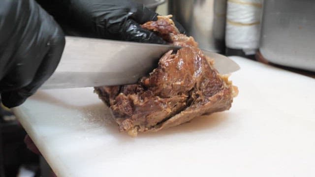 촉촉하게 요리된 고기를 자르는 사람