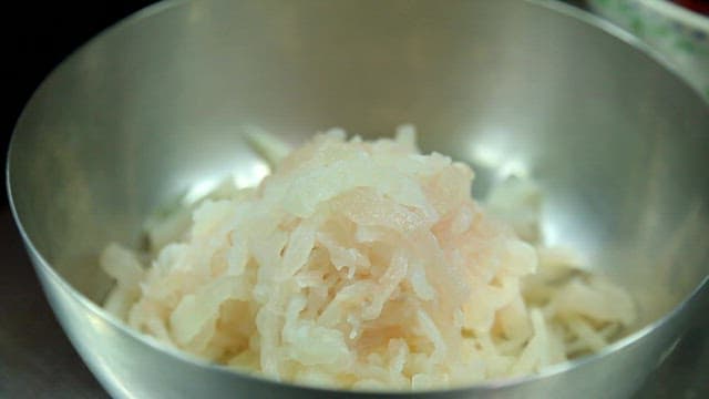 Putting red pepper paste in sliced raw fish