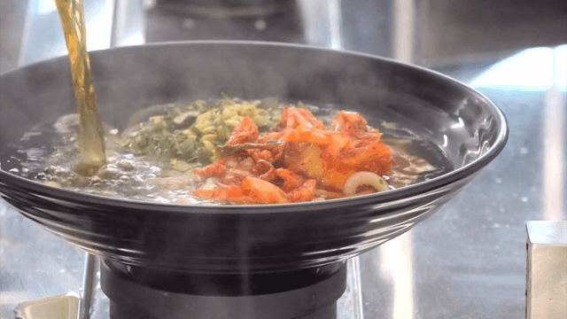 김치 우동에 육수 붓는 장면