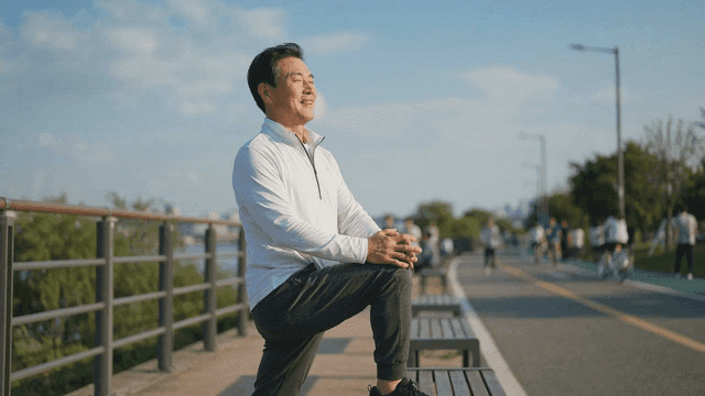 Middle-aged man stretching on riverside path