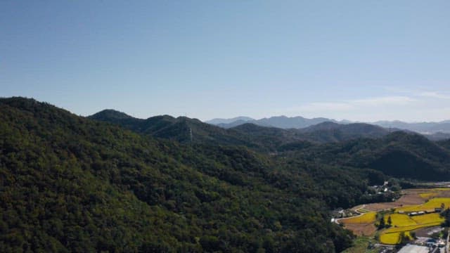 Green mountains stretching out under a clear blue sky