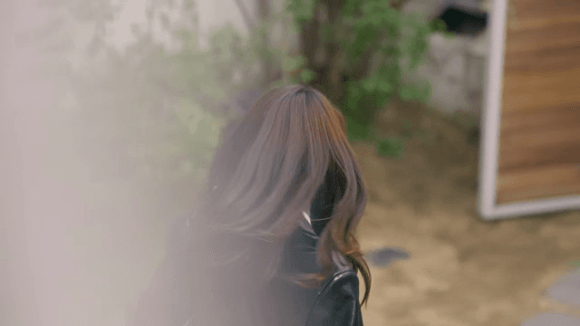 집을 나서며 미소 짓고 인사하는 여성