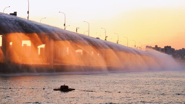 Water fountain on a bridge during sunset