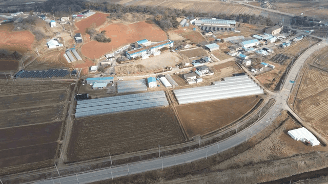 비닐하우스와 들판이 있는 시골 마을