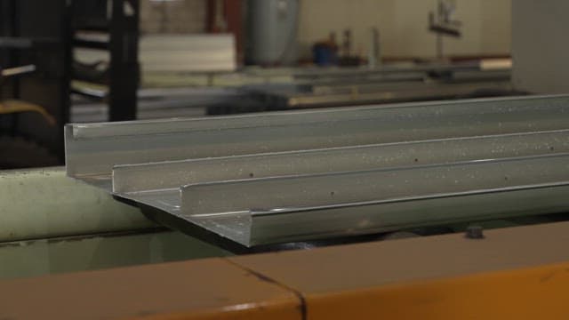 Metal beams on a conveyor in a factory