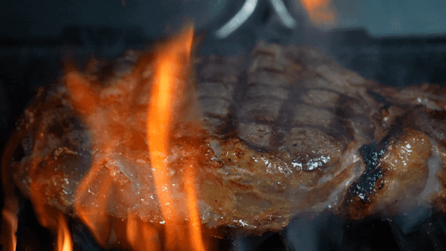Juicy steak grilling over open flames