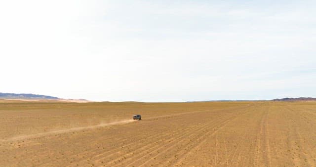 Vehicle driving through a vast desert