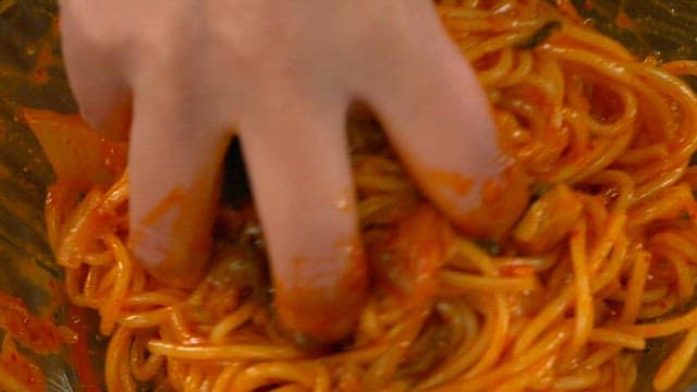 Mixing spicy noodles with hand