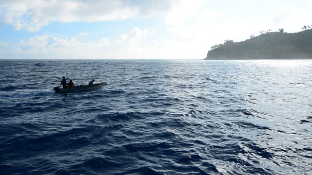 People on a boat heading to the island on a clear day