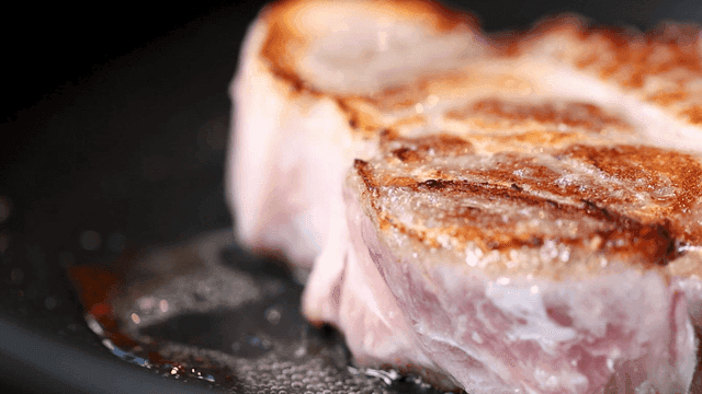 Thick pork sizzling in pan