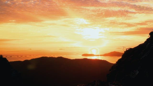 산과 바다 위의 생동감 넘치는 일몰