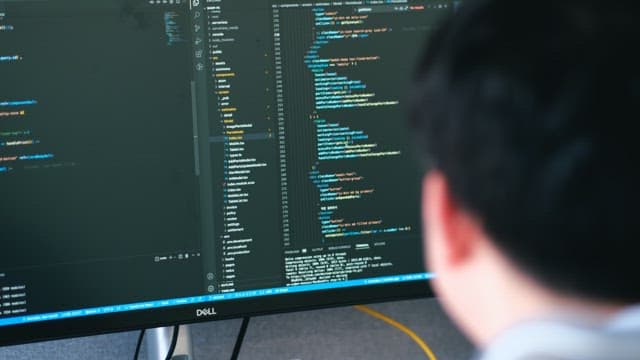 Back of a Man Programming on a Computer