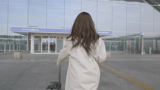 공항 터미널로 걸어가는 여성의 뒷모습