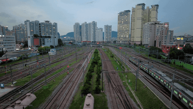 Train station with moving trains in city landscape