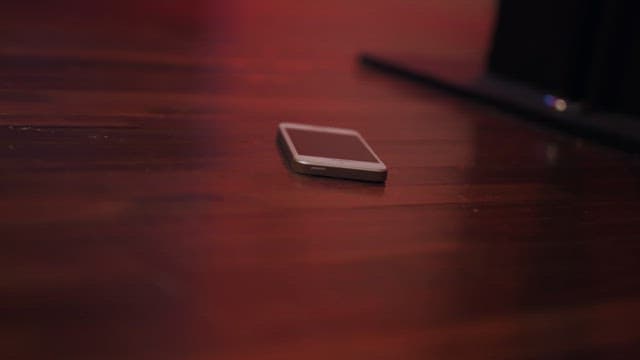 어두운 나무 바닥에 놓인 스마트폰