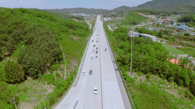 A highway surrounded by lush green forests