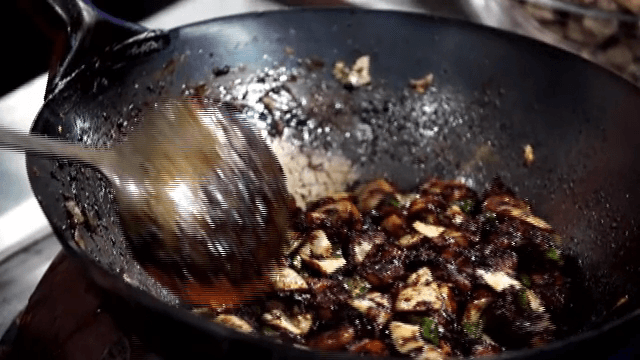 뜨거운 웍에서 춘장과 함께 채소와 고춧가루를 볶는 모습