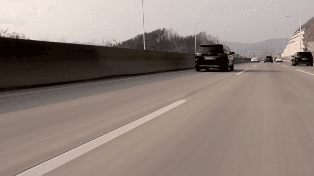 Cars running on a highway with a view of the mountains