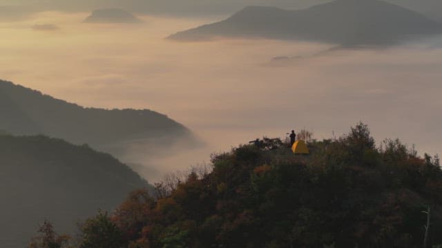 구름 낀 산 꼭대기에서 캠핑하는 모습