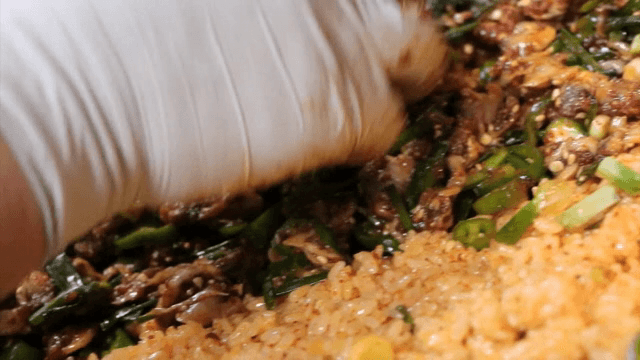 Putting seasoned cockles and rice in a bowl