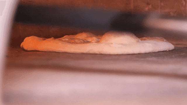 Pizza baked in hot wood-fired oven